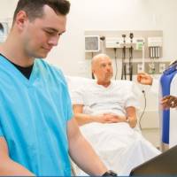 LEARNING BY DOING: Medical scribes work one-on-one with health care providers by documenting patient care in real-time, at the bedside, and through the use of electric medical records.